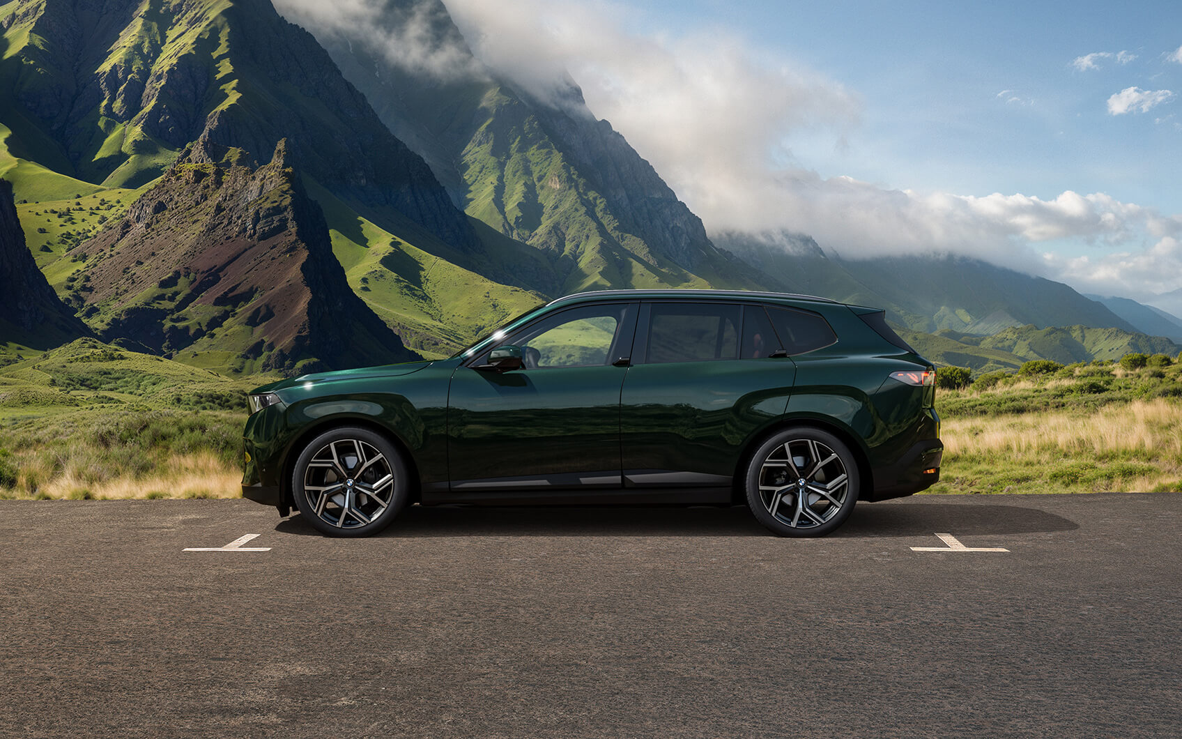 Grüner BMW X5 in Seitenansicht auf einem Parkplatz vor Berglandschaft