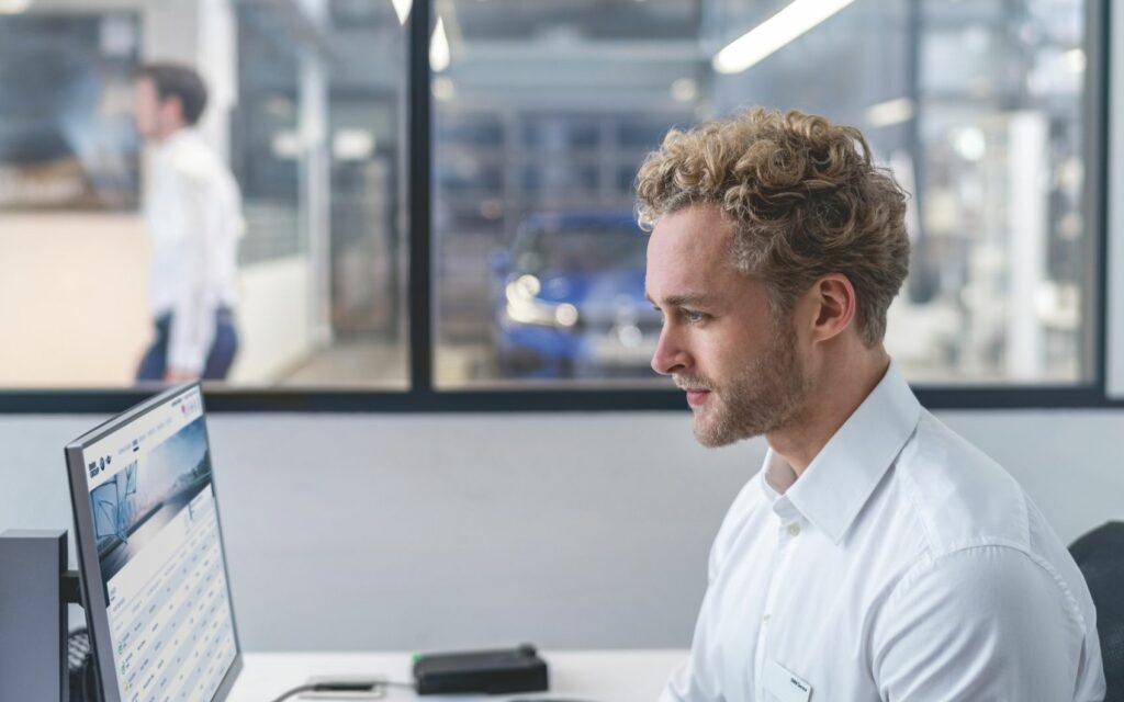 Serviceleiter am Computer in einer Autowerkstatt
