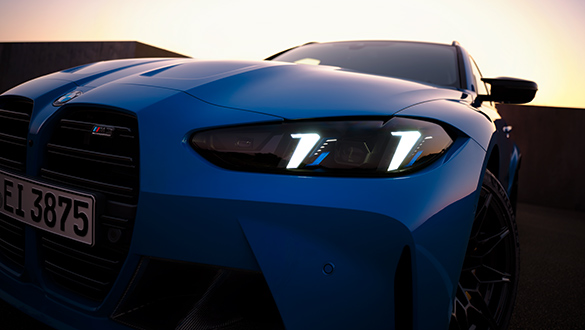 Nahaufnahme der Front des blauen BMW 3er Competition Touring M Automobils mit Fokus auf Scheinwerfer