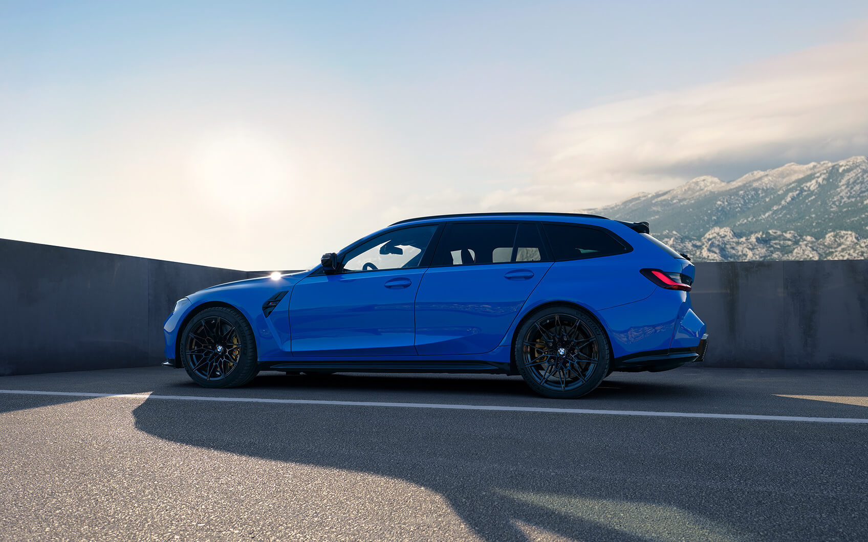Blauer BMW M3 Competition Touring auf Asphalt