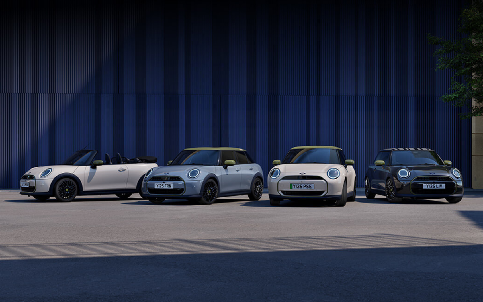 Vier MINI Paul Smith Edition Modelle stehen vor einer modernen blauen Gebäudefassade.