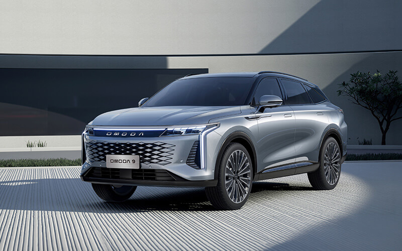 Silberner OMODA 9 SUV vor moderner Architektur.