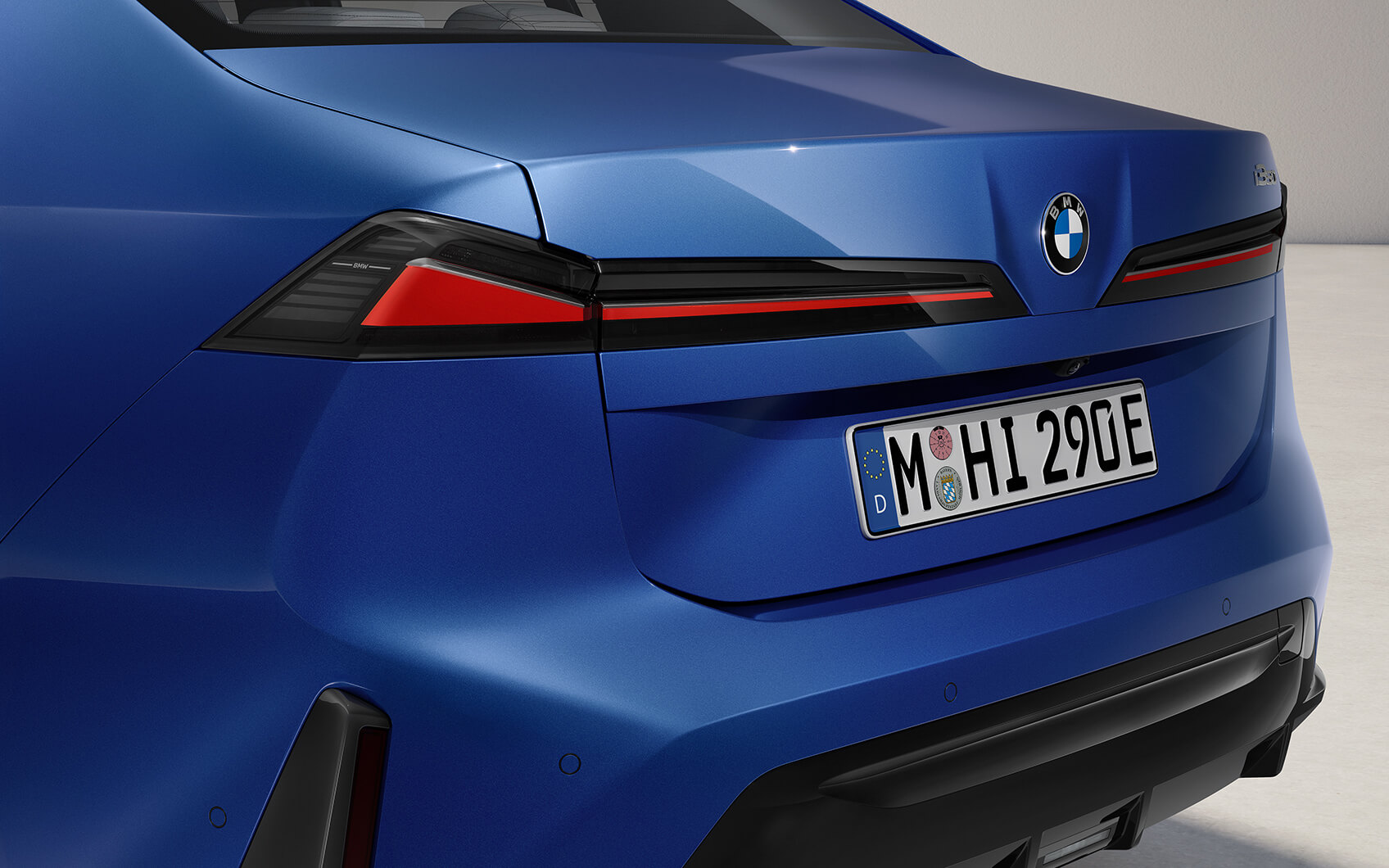 Heck einer blauen BMW i3 Limousine mit schlanken, weit nach außen gezogenen Lichtelementen